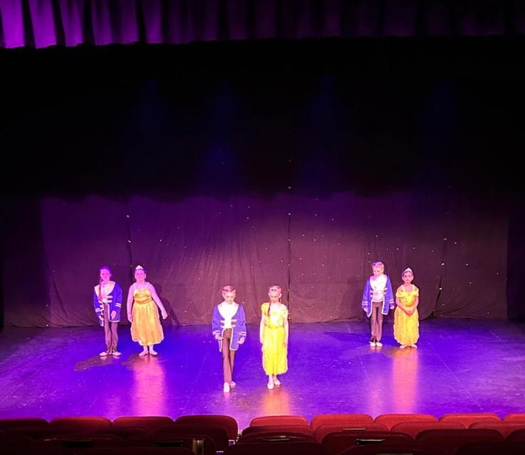 Acro team holding balance pose during school performance